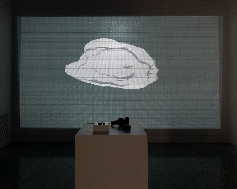 Projection of fog imagery with controls on a pedestal in the foreground.