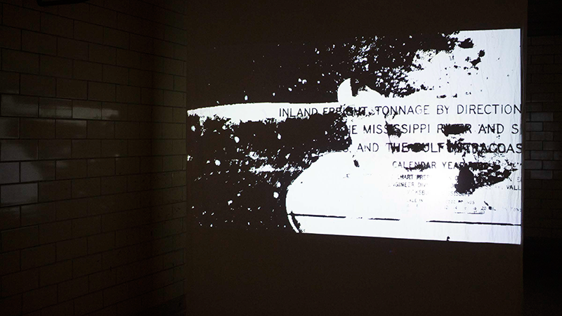 Installation image of Project Bodies featuring a back-projected black and white graphic image in a xerox style.