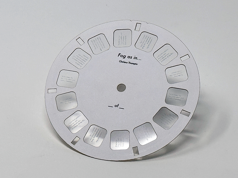 A white laser cut cardstock disc contaiing grayscale film images for a View-Master.